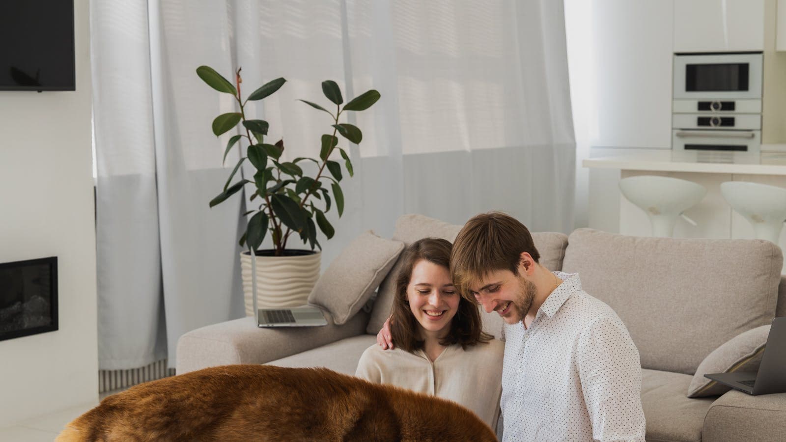 Couple sitting in a living room with their dog